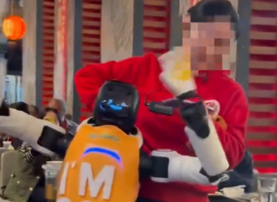 Haidilao restaurant robot being restrained during freakout