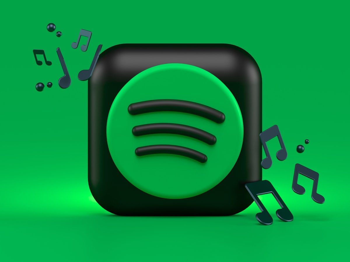 Spotify app on a smartphone displaying AI-generated fake tracks uploaded via voice cloning fraud