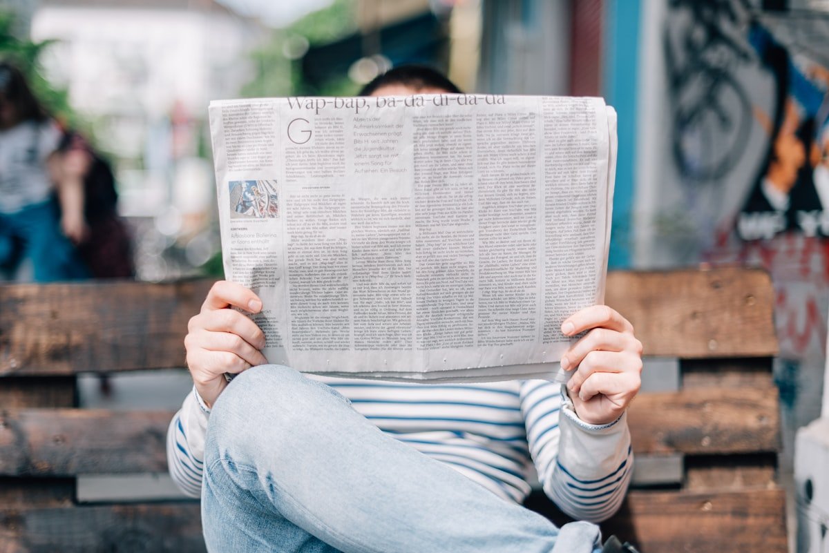 Newspaper headlines on a newsstand contrasting traditional media with BBC RSS feed's blank digital headlines